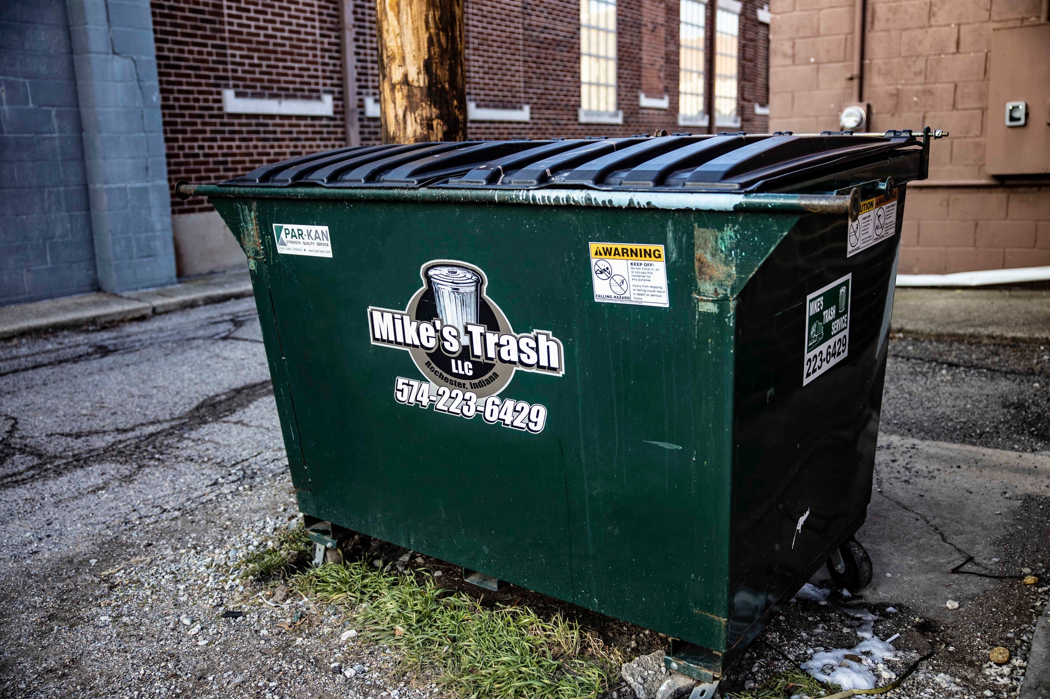 Mike's Trash dumpster with company logo